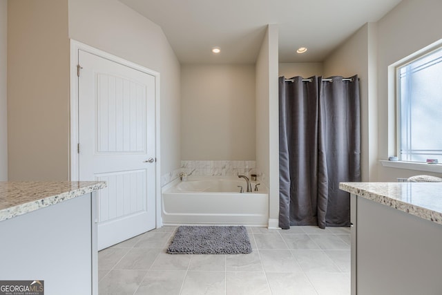 full bath with tile patterned flooring, a garden tub, vanity, and recessed lighting