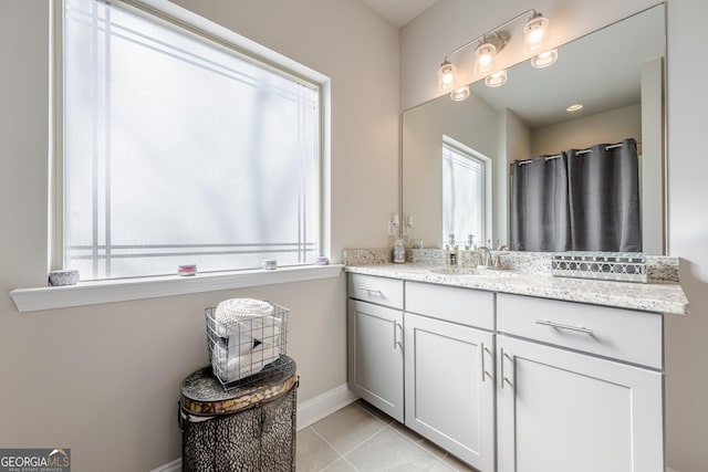 full bath with curtained shower, vanity, baseboards, and tile patterned floors