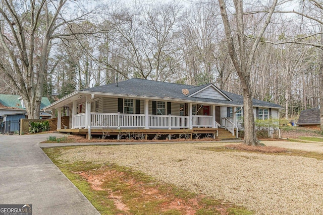 view of front facade with a front yard, covered porch, and driveway