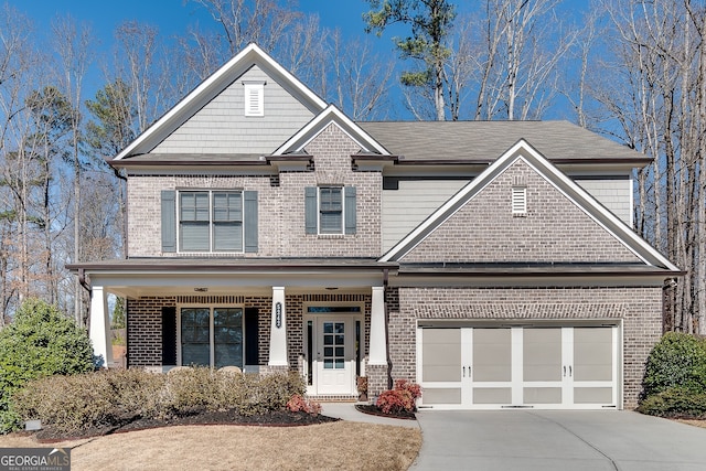 craftsman-style house with a garage, brick siding, and driveway