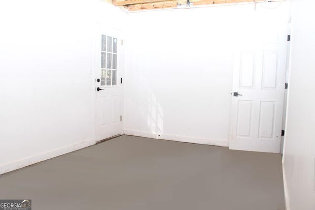 unfurnished room featuring finished concrete floors and baseboards