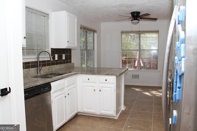 kitchen with stainless steel appliances, tasteful backsplash, visible vents, white cabinetry, and a sink