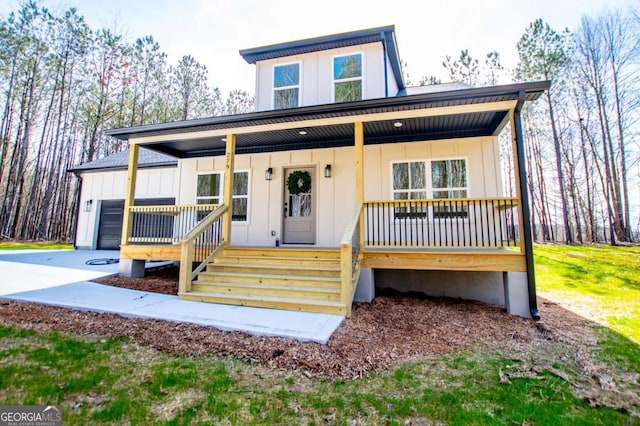 view of front of house featuring a garage, covered porch, driveway, and board and batten siding