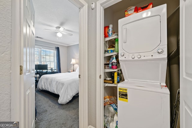 laundry room with ceiling fan, a textured wall, carpet floors, stacked washer / dryer, and crown molding