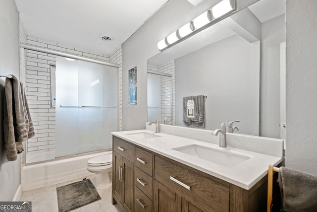 full bath featuring shower / bath combination with glass door, visible vents, a sink, and double vanity