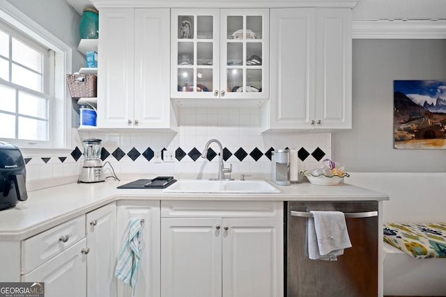 kitchen with glass insert cabinets, white cabinetry, dishwasher, and a sink