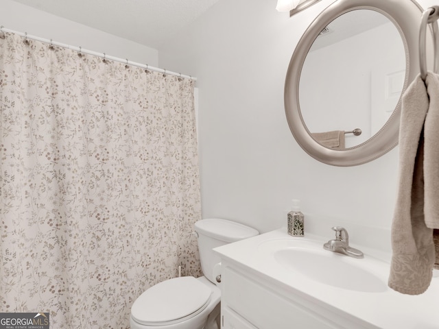 bathroom with toilet, curtained shower, and vanity