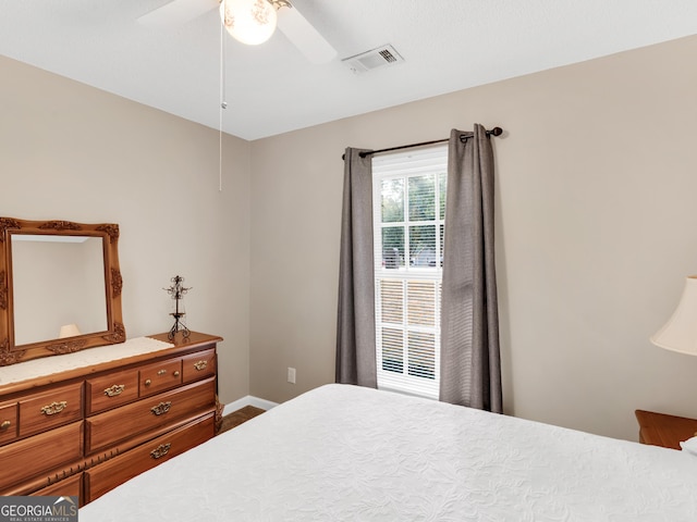 bedroom with a ceiling fan, visible vents, and baseboards