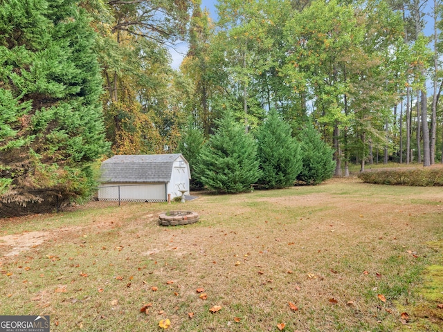 view of yard featuring an outbuilding, an outdoor fire pit, and a storage shed