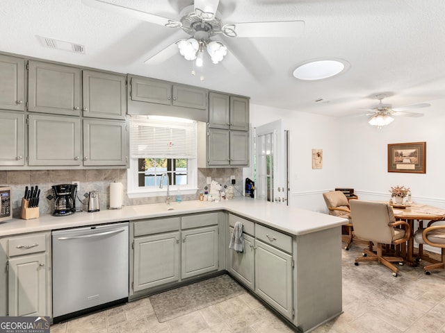 kitchen with a peninsula, a sink, visible vents, light countertops, and dishwasher