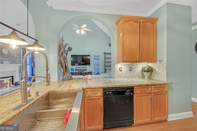 kitchen with a warm lit fireplace, light stone counters, a sink, black dishwasher, and ornamental molding