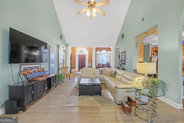 living area featuring light wood-style floors, decorative columns, visible vents, and a ceiling fan