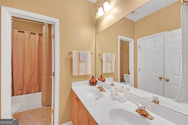 bathroom with double vanity, a sink, toilet, and shower / bathtub combination with curtain