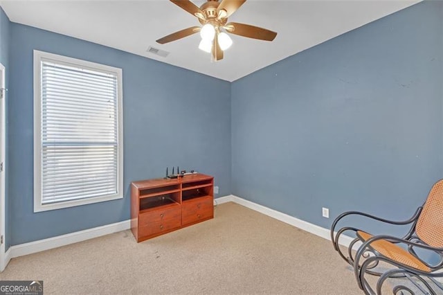 living area featuring carpet floors, baseboards, visible vents, and a ceiling fan