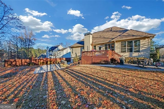 rear view of property featuring a wooden deck