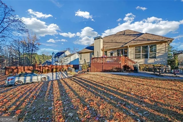 rear view of house featuring a wooden deck