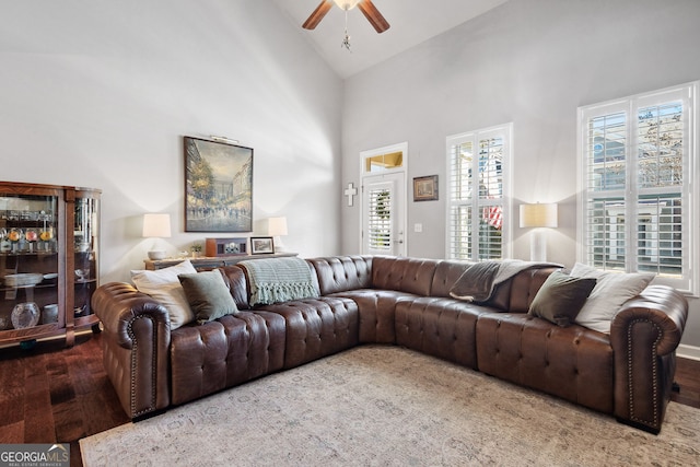 living area with high vaulted ceiling, a ceiling fan, and wood finished floors