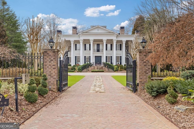 view of front facade featuring a fenced front yard, a gate, and a chimney