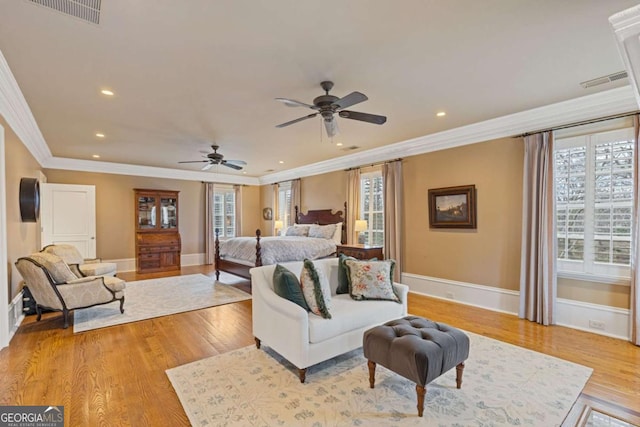 bedroom with ornamental molding, visible vents, and light wood-style floors