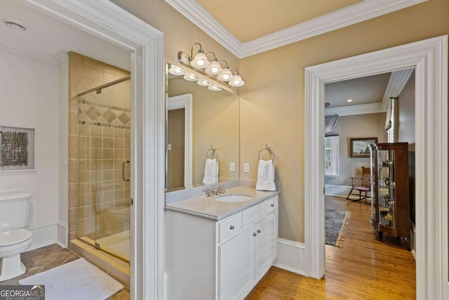 bathroom featuring toilet, a shower stall, ornamental molding, and vanity