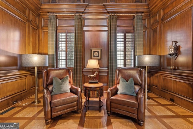 sitting room featuring wooden walls and a decorative wall