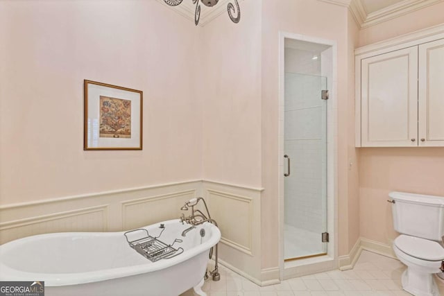 bathroom with crown molding, a freestanding bath, toilet, wainscoting, and a shower stall