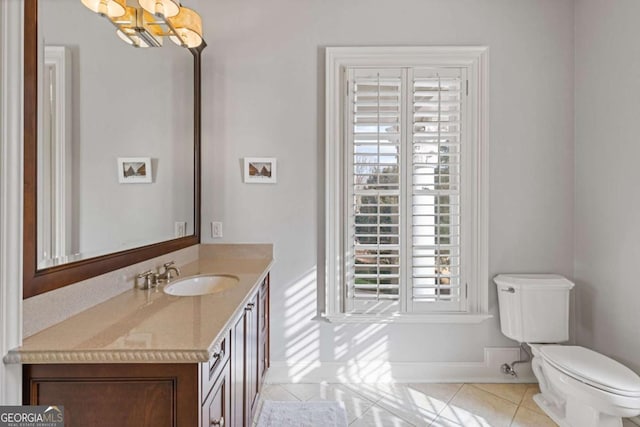 bathroom featuring toilet, vanity, a chandelier, baseboards, and tile patterned floors