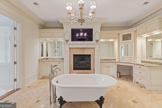 full bathroom featuring a fireplace, vanity, visible vents, a freestanding bath, and ornamental molding