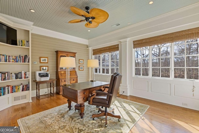 office featuring ornamental molding, visible vents, ceiling fan, and wood finished floors