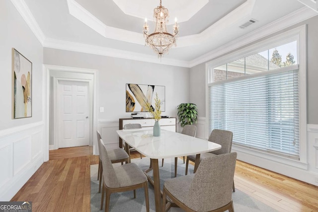 2477 Misty Rose Ln, Loganville, GA 30052 - dining space featuring a tray ceiling, light wood-style flooring, a notable chandelier, and visible vents