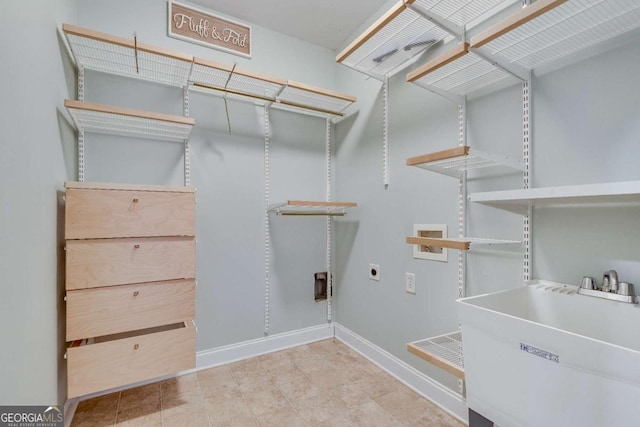 clothes washing area featuring laundry area, baseboards, hookup for an electric dryer, washer hookup, and a sink