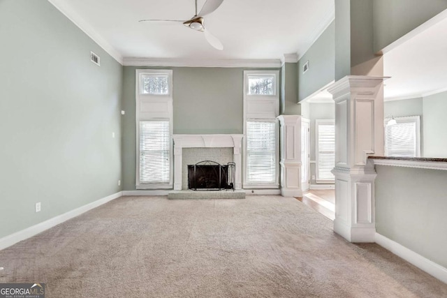 unfurnished living room featuring carpet floors, decorative columns, baseboards, and crown molding