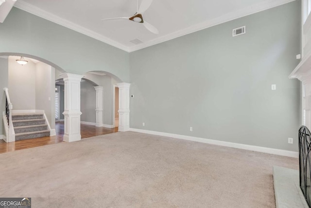 unfurnished living room featuring arched walkways, carpet, visible vents, and crown molding