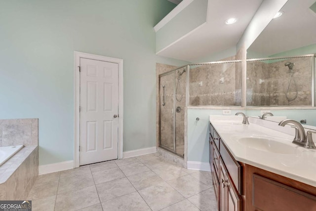 bathroom featuring double vanity, tiled bath, a sink, a shower stall, and tile patterned flooring