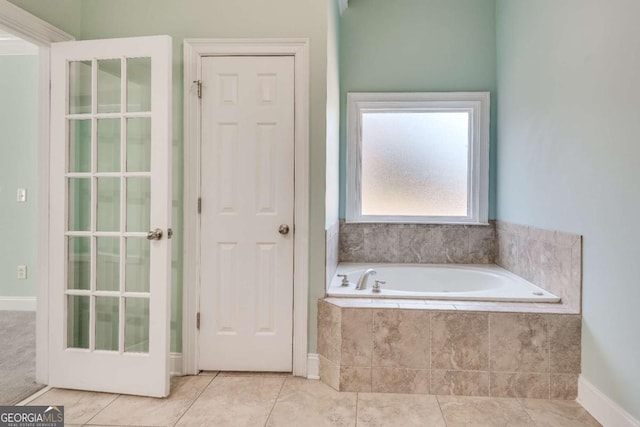 bathroom with tile patterned flooring and a bath