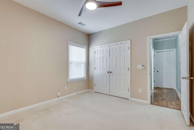 unfurnished bedroom with carpet flooring, a ceiling fan, visible vents, baseboards, and a closet