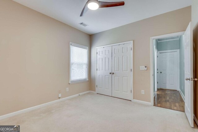 2477 Misty Rose Ln, Loganville, GA 30052 - unfurnished bedroom featuring visible vents, baseboards, ceiling fan, light colored carpet, and a closet