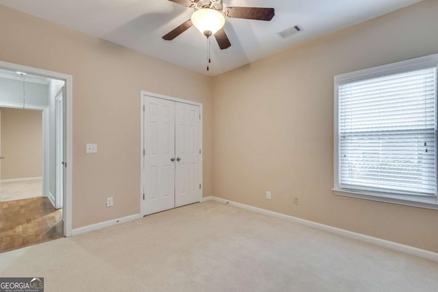 unfurnished bedroom with carpet, a closet, visible vents, attic access, and baseboards