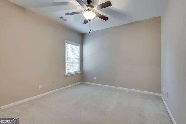 spare room with light carpet, baseboards, visible vents, and ceiling fan