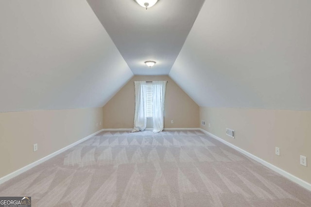 bonus room with carpet floors, baseboards, visible vents, and vaulted ceiling