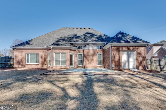 view of front of property with brick siding, a front lawn, and fence