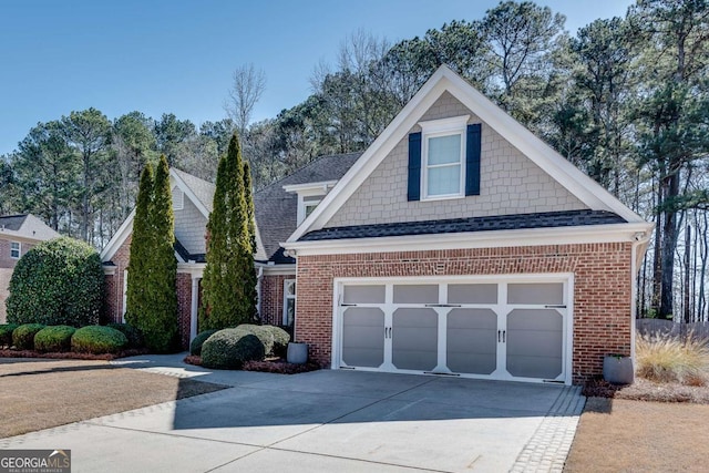 view of front of property featuring a garage, concrete driveway, brick siding, and a shingled roof