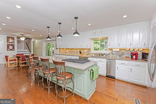 kitchen featuring visible vents, a breakfast bar area, and white cabinets