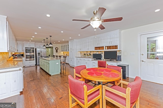 dining area with a toaster, wood-type flooring, a ceiling fan, and recessed lighting