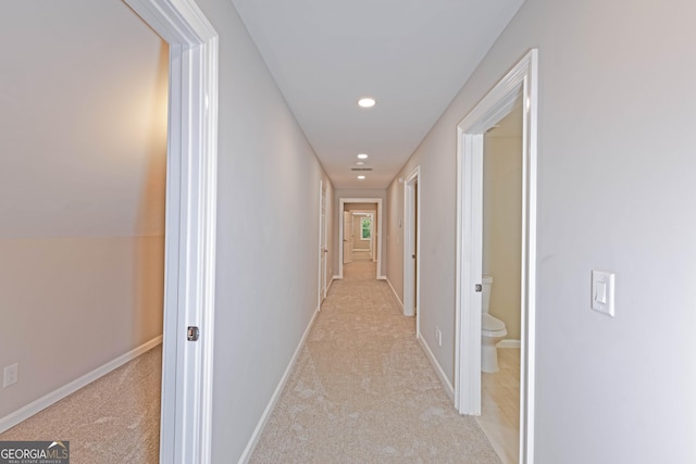 corridor featuring recessed lighting, light colored carpet, and baseboards