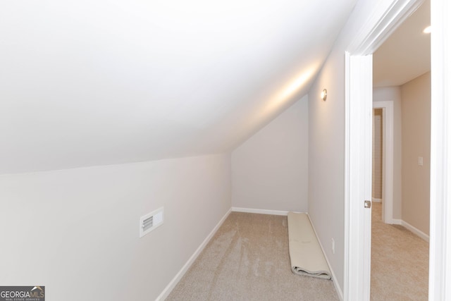 bonus room featuring lofted ceiling, light carpet, and baseboards