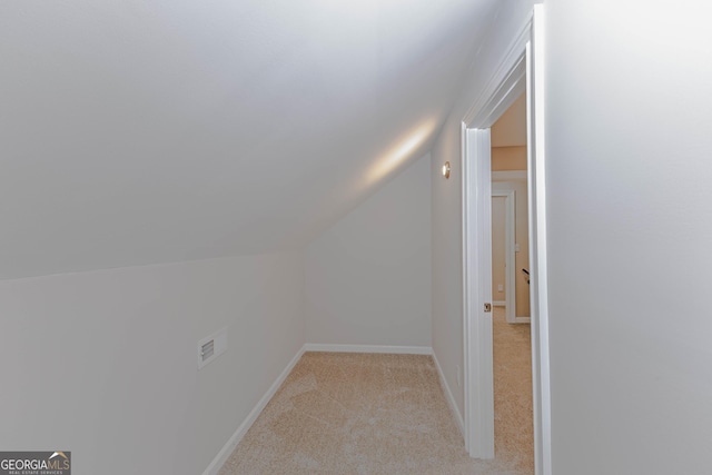 bonus room featuring light carpet, vaulted ceiling, and baseboards