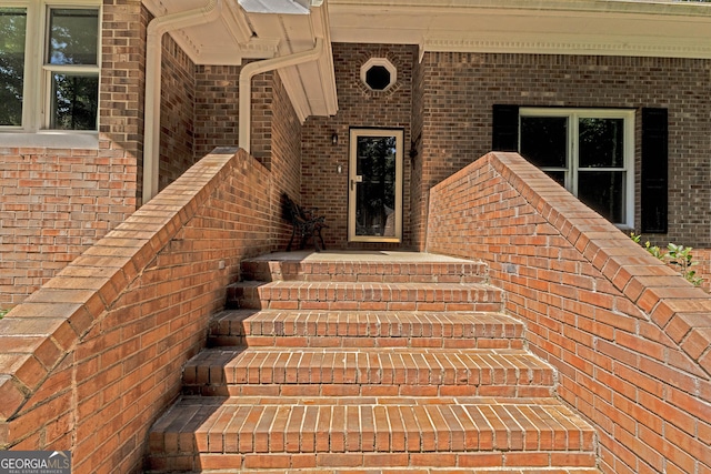 view of exterior entry featuring brick siding