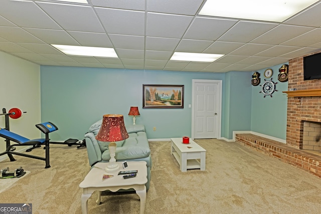 sitting room with a fireplace, baseboards, a drop ceiling, and carpet flooring