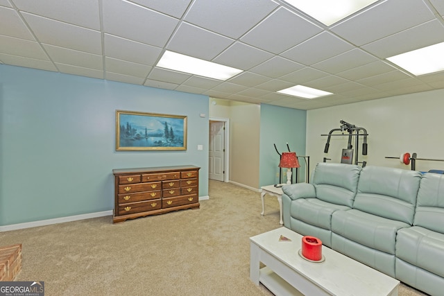 living room with carpet, a drop ceiling, and baseboards